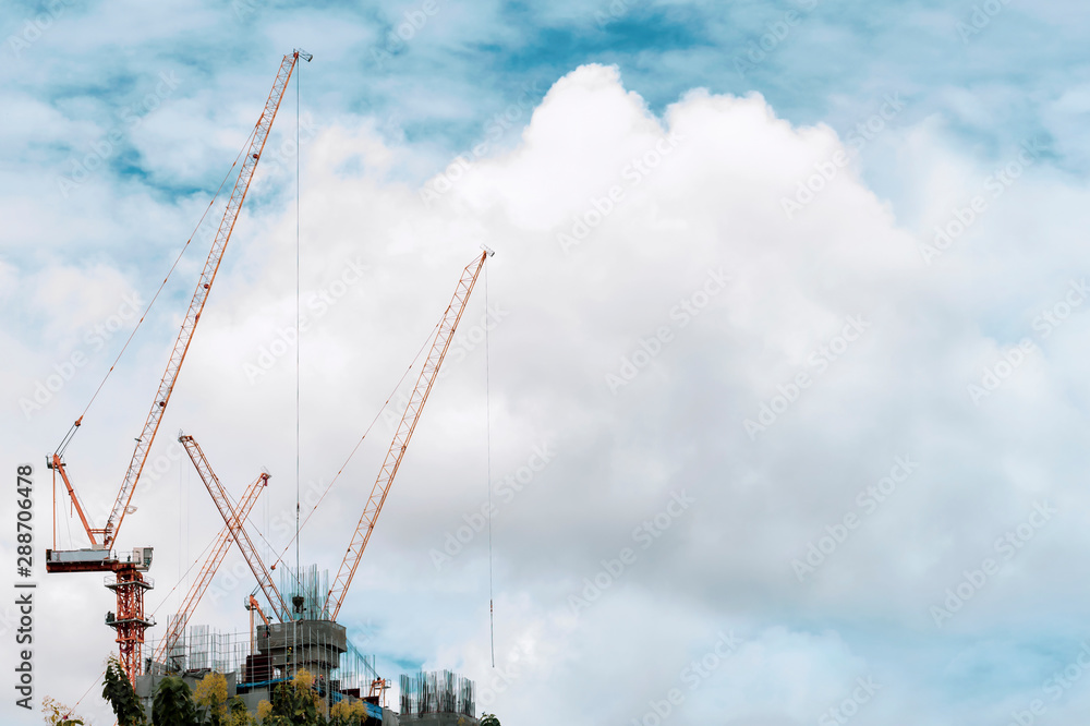 Building construction of modern real estate home with tower cranes under construction working site in the urban on sky background. The modern building with prosperity of the capital. Building construction of modern real estate home with tower cranes under construction working site in the urban on sky background. The modern building with prosperity of the capital.