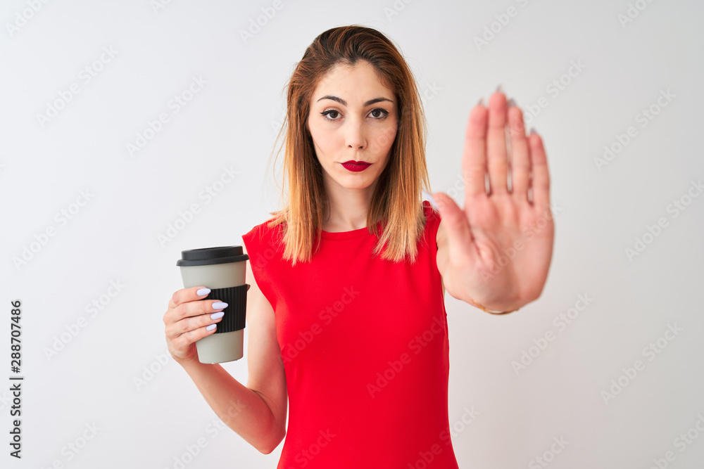 Young beautiful redhead woman drinking take away coffee over isolated white background with open hand doing stop sign with serious and confident expression, defense gesture Young beautiful redhead woman drinking take away coffee over isolated white background with open hand doing stop sign with serious and confident expression, defense gesture