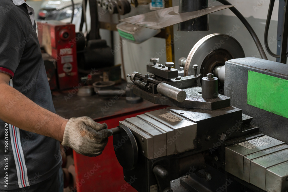 Mechanic man repairing brake use lathe tool polishing disc brakes of cars working automatic. - rebuild disc brake surface. Mechanic man repairing brake use lathe tool polishing disc brakes of cars working automatic. - rebuild disc brake surface.