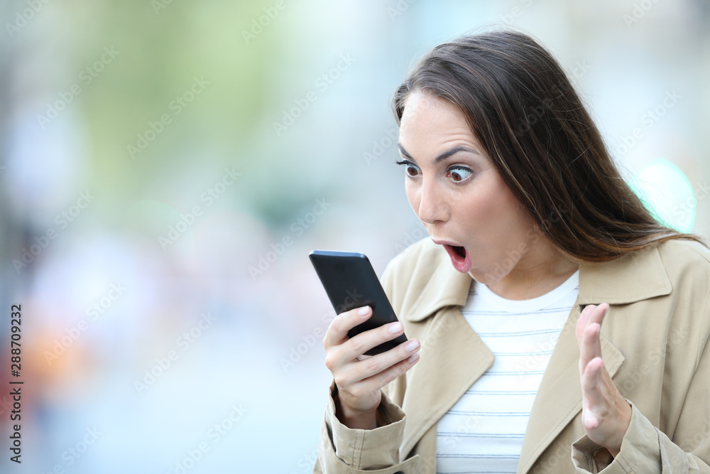 Shocked woman finding surprising news on phone Shocked woman finding surprising news on phone