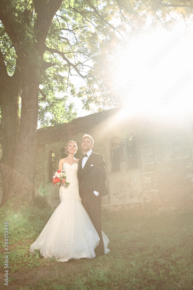 couples of newlyweds standing near the old manor in the evening couples of newlyweds standing near the old manor in the evening