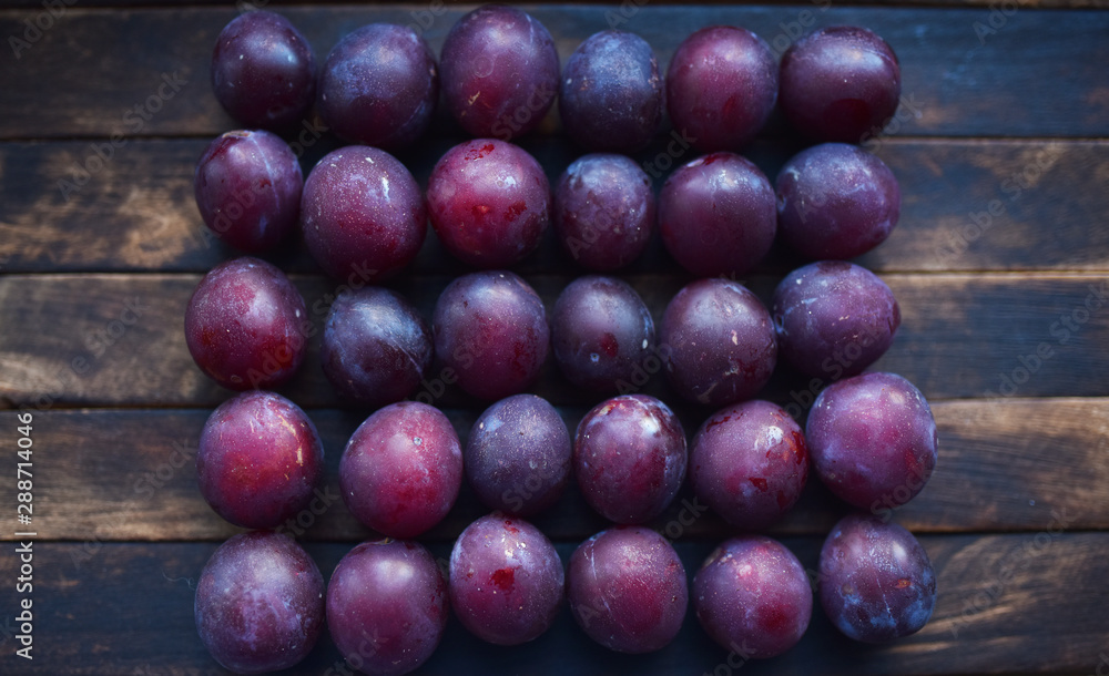 lots of ripe plums on a wooden table lots of ripe plums on a wooden table