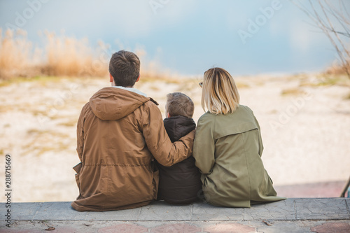 young beautiful family sitting at beach with view lake