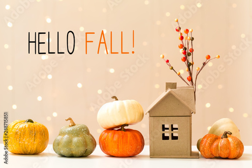 Fototapeta Naklejka Na Ścianę i Meble -  Hello fall message with collection of autumn pumpkins with a toy house