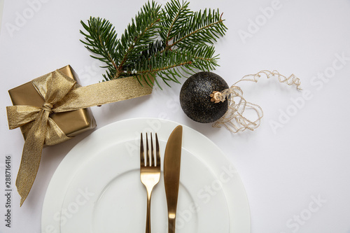 Table setting, xmas, new year. Gold cutlery on white set of dishes, white background