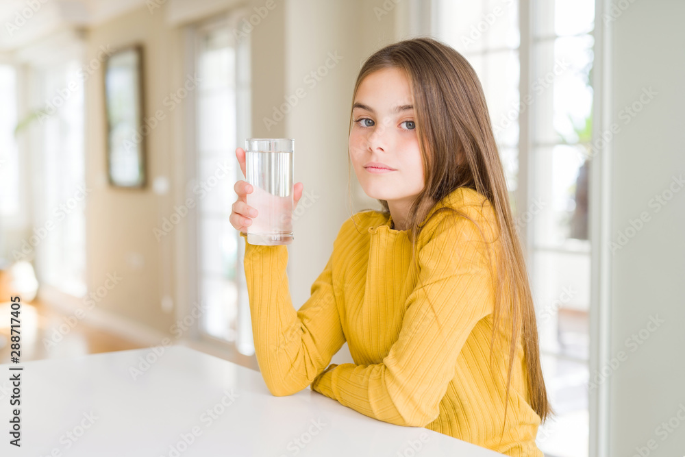 Beautiful young girl kid drinking a fresh glass of water with a confident expression on smart face thinking serious Beautiful young girl kid drinking a fresh glass of water with a confident expression on smart face thinking serious