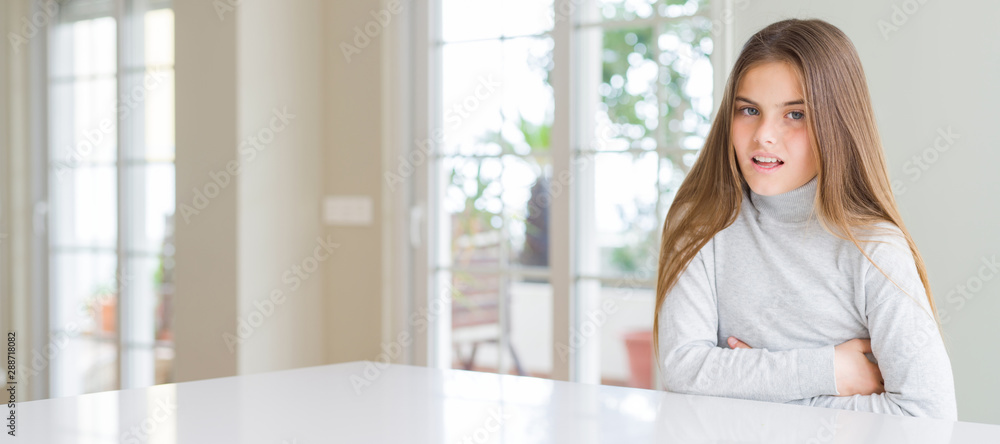 Wide angle picture of beautiful young girl kid wearing casual sweater with hand on stomach because nausea, painful disease feeling unwell. Ache concept.