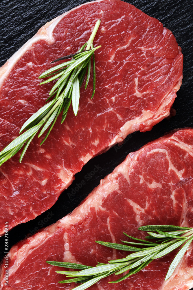 Steak raw. Barbecue Rib Eye Steak or rump steak on dark rustic table Steak raw. Barbecue Rib Eye Steak or rump steak on dark rustic table