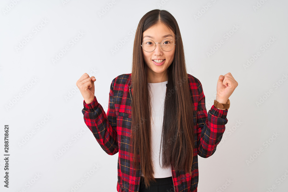 Young chinese woman wearing casual jacket and glasses over isolated white background celebrating surprised and amazed for success with arms raised and open eyes. Winner concept. Young chinese woman wearing casual jacket and glasses over isolated white background celebrating surprised and amazed for success with arms raised and open eyes. Winner concept.