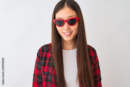 Young chinese woman wearing casual jacket and sunglasses over isolated white background with a happy face standing and smiling with a confident smile showing teeth © Krakenimages.com