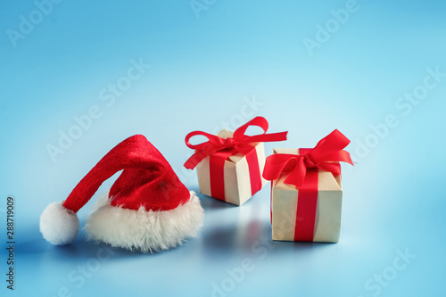 Gift boxes and Santa hat on blue background. Christmas gift.