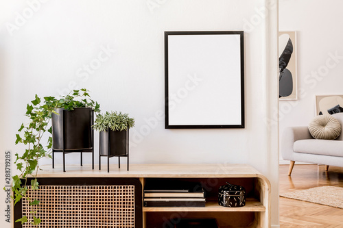 Plakat Modern scandinavian home interior with mock up photo frame, design wooden commode, plants in black pots, gray sofa, books and personal accessories. Stylish home decor. Template. Ready to use. 