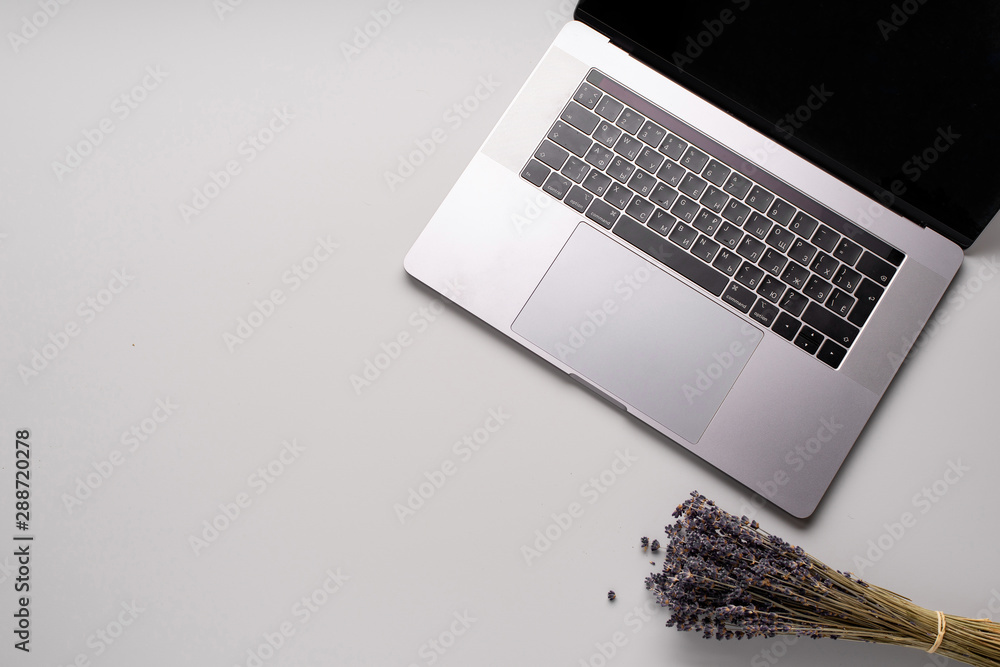 Flatlay with laptop and lavender flowers on gray background. Workspace concept. Copy space Flatlay with laptop and lavender flowers on gray background. Workspace concept. Copy space