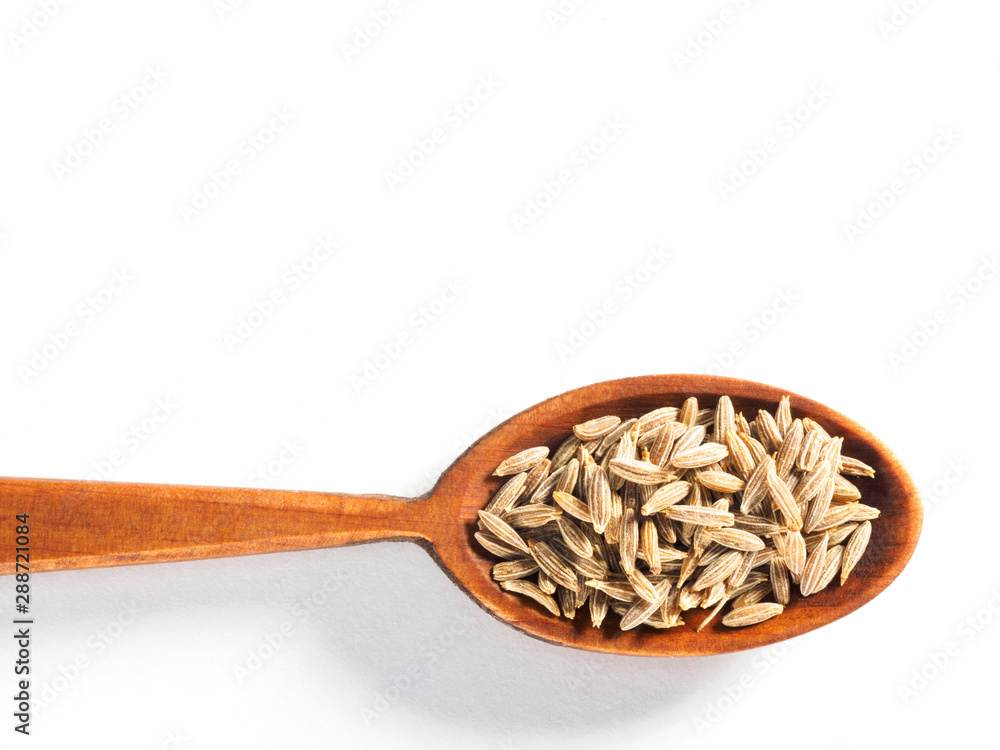 Cumin seeds (Cuminum), Jeera, in a wooden spoon on a white background horizontally Cumin seeds (Cuminum), Jeera, in a wooden spoon on a white background horizontally