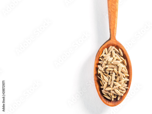 Cumin seeds (Cuminum), Jeera in wooden spoon on a white background vertically