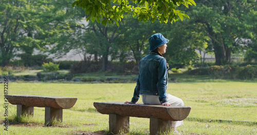 Woman sits on the wooden bench