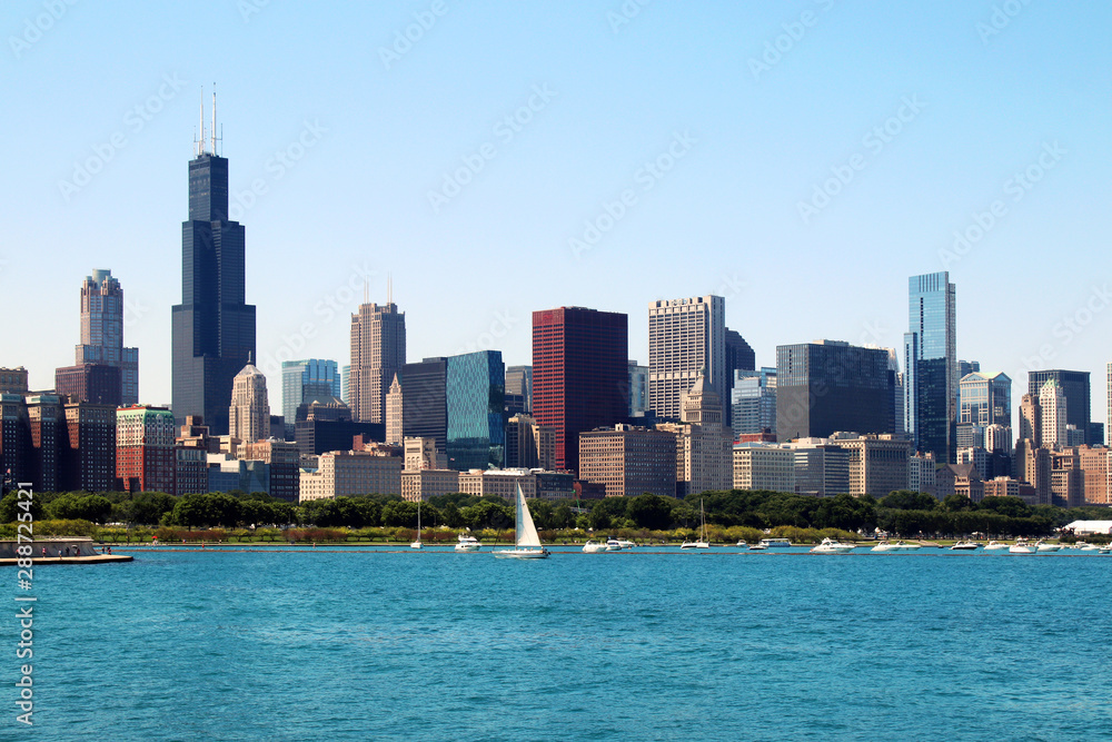 Fototapeta premium Panoramę centrum Chicago z jeziorem Michigan.Sceniczny letni pejzaż z drapaczami chmur nad jeziorem Chicago z dryfującymi jachtami w porcie nad jeziorem Michigan. Tło architektury amerykańskiego miasta miejskiego.