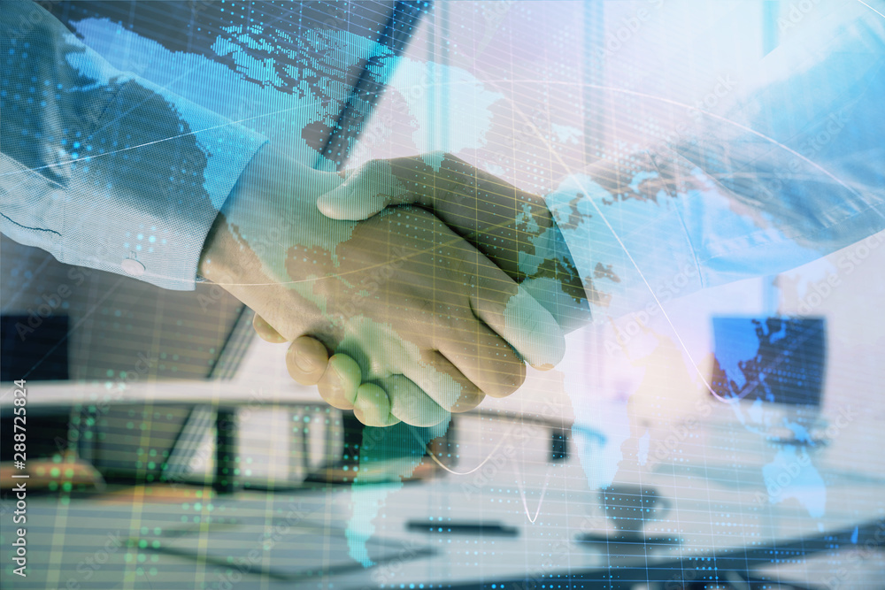 Multi exposure of world map on office background with two businessmen handshake. Concept of international business Multi exposure of world map on office background with two businessmen handshake. Concept of international business