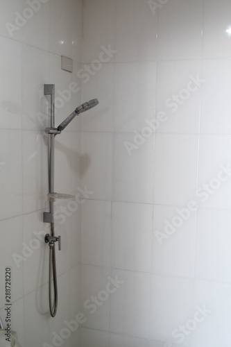 Modern shower head on white wall in the bathroom.