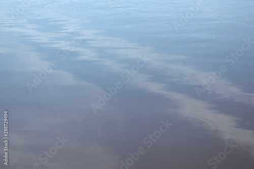 reflection of the blue sky in a deep river