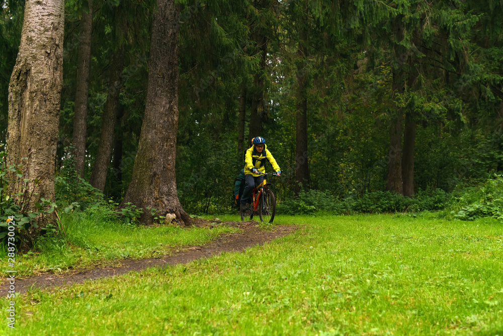 equipped cycling tourist on a trail in the forest