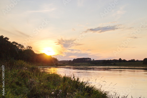 Sunset by the river in the summer countryside © Andrey
