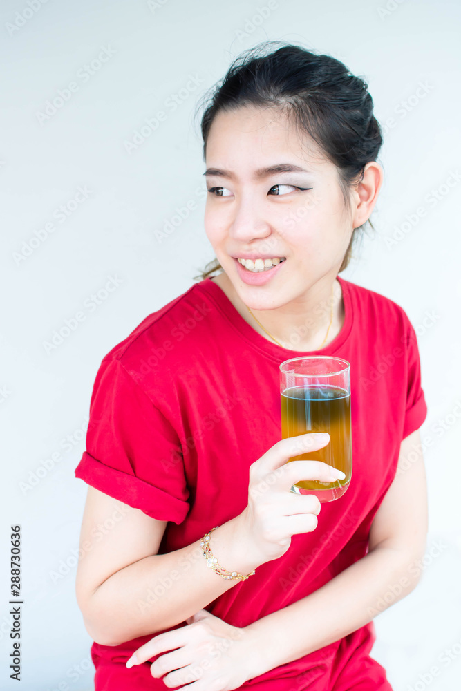 Woman in red shirt is sitting and holding a glass of green tea Woman in red shirt is sitting and holding a glass of green tea