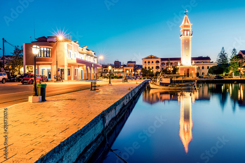Colorful evening view of Greece island Zakynthos. Illuminated spring scene of town hall and empty street of Zakynthos city, Ionian Sea, Greece, Europe. Traveling concept background.