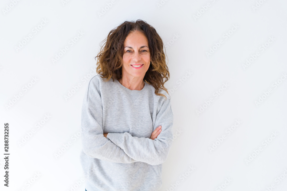 Beautiful middle age woman with curly hair smiling cheerful and happy with arms crossed, laughing with a big smile on face showing teeth over white isolated background Beautiful middle age woman with curly hair smiling cheerful and happy with arms crossed, laughing with a big smile on face showing teeth over white isolated background