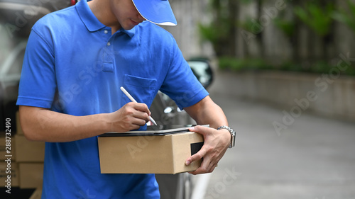Delivery man checking list on tablet with stylus pen.