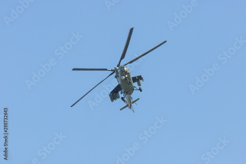 A military helicopter flying in the blue sky