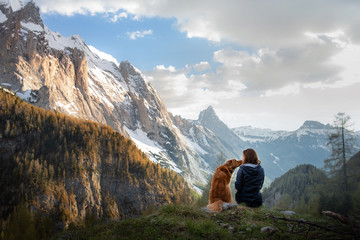 girl with a dog in the mountains. Autumn mood. Traveling with a pet. Nova Scotia Duck Tolling Retriever