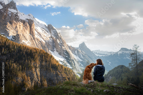 girl with a dog in the mountains. Autumn mood. Traveling with a pet. Nova Scotia Duck Tolling Retriever