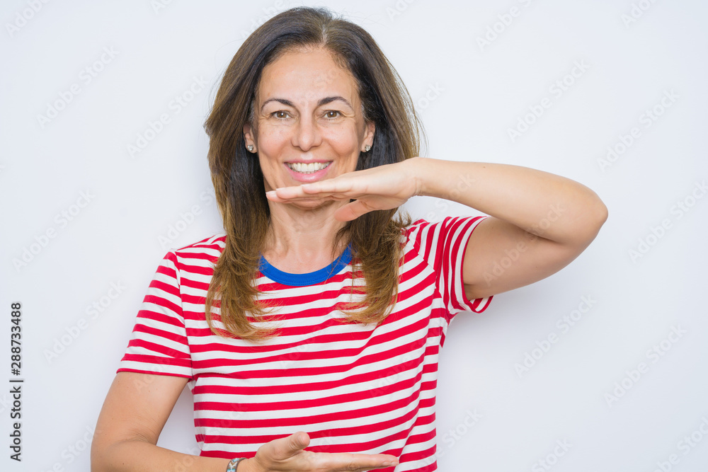Middle age senior woman standing over white isolated background gesturing with hands showing big and large size sign, measure symbol. Smiling looking at the camera. Measuring concept. Middle age senior woman standing over white isolated background gesturing with hands showing big and large size sign, measure symbol. Smiling looking at the camera. Measuring concept.