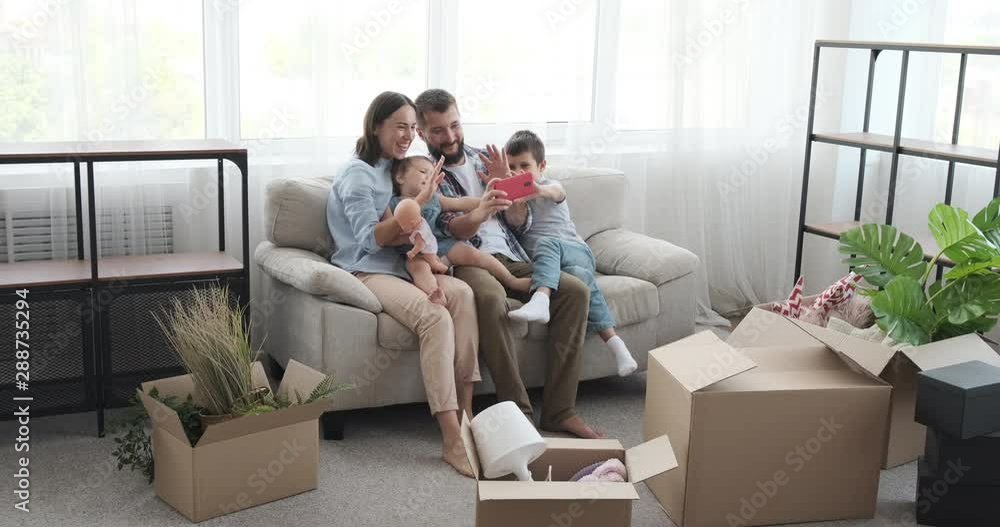 Happy family doing video call using mobile phone in new apartment Happy family doing video call using mobile phone in new apartment