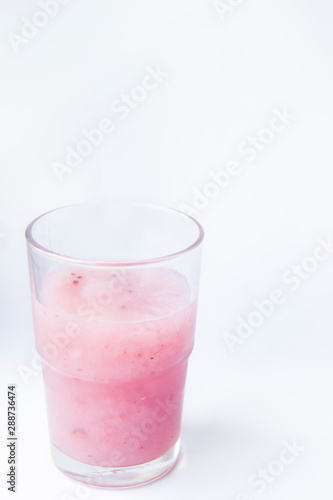 Drinking yogurt in a glass on a white background. Beautiful delicious pink fruit yogurt. Natural detoxification. Healthy eating concept. Fresh homemade yogurt for Breakfast. Fruit yogurt smoothie.