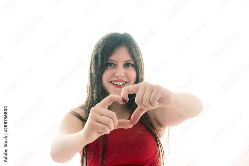 Portrait of a teenage girl making heart with her hand Portrait of a teenage girl making heart with her hand