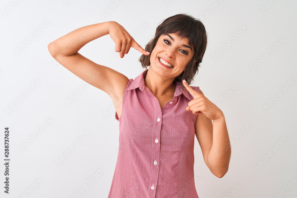 Young beautiful woman wearing red summer shirt standing over isolated white background smiling cheerful showing and pointing with fingers teeth and mouth. Dental health concept. Young beautiful woman wearing red summer shirt standing over isolated white background smiling cheerful showing and pointing with fingers teeth and mouth. Dental health concept.