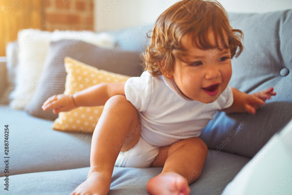 Beautiful toddler child girl wearing white t-shirt sitting on the sofa Beautiful toddler child girl wearing white t-shirt sitting on the sofa