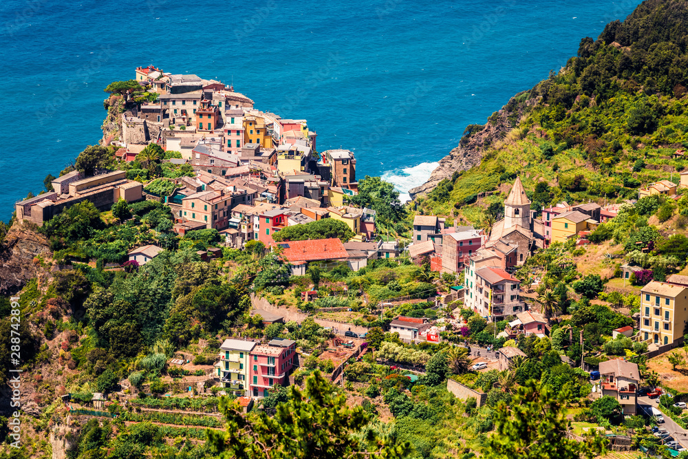 Third village of the Cique Terre sequence of hill cities - Corniglia. Sunny spring morning in Liguria, Italy, Europe. Picturesqie seascape of Mediterranean sea. Traveling concept background.