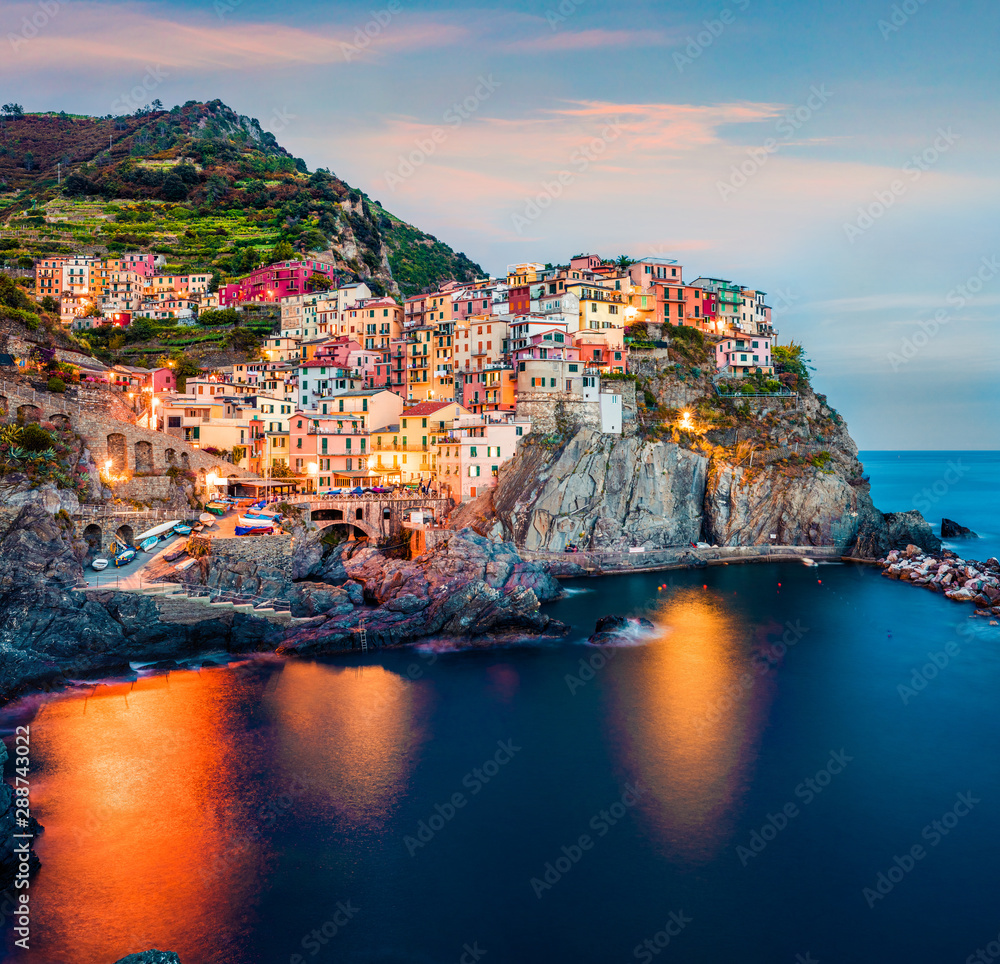 Second city of the Cique Terre sequence of hill cities - Manarola. Impressive spring sunset in Liguria, Italy, Europe. Picturesqie seascape of Mediterranean sea. Traveling concept background.