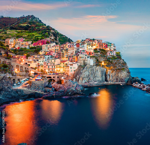 Second city of the Cique Terre sequence of hill cities - Manarola. Impressive spring sunset in Liguria, Italy, Europe. Picturesqie seascape of Mediterranean sea. Traveling concept background.