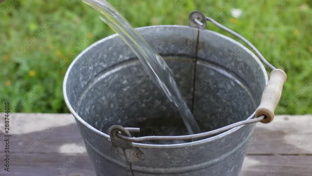 Old metal bucket is filled with water Old metal bucket is filled with water