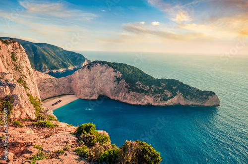 Colorful spring view of Navagio beach with shipwreck. Sunny evening seascape of Ionian Sea, Zakynthos (Zante) island, Greece, Europe. Beauty of nature concept background.