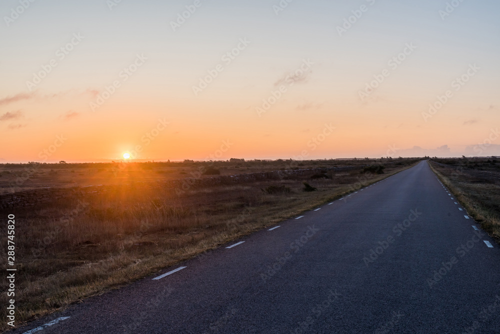 Sunrise by a straight country road in a great plain grassland Sunrise by a straight country road in a great plain grassland