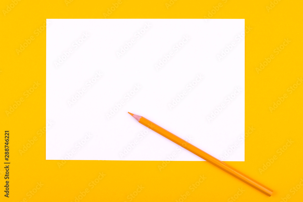 A white sheet of paper for drawings, texts and notes next to a pencil lies on an orange background A white sheet of paper for drawings, texts and notes next to a pencil lies on an orange background