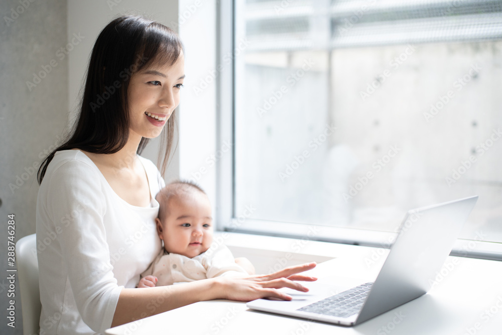 Young woman using laptop computer with her baby Young woman using laptop computer with her baby
