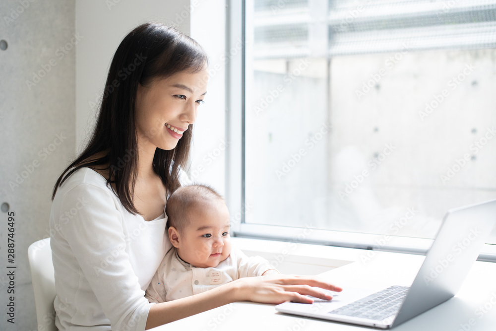 Young woman using laptop computer with her baby Young woman using laptop computer with her baby