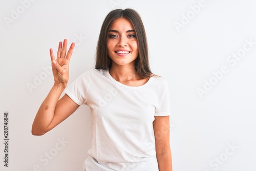Wallpaper Mural Young beautiful woman wearing casual t-shirt standing over isolated white background showing and pointing up with fingers number four while smiling confident and happy. Torontodigital.ca