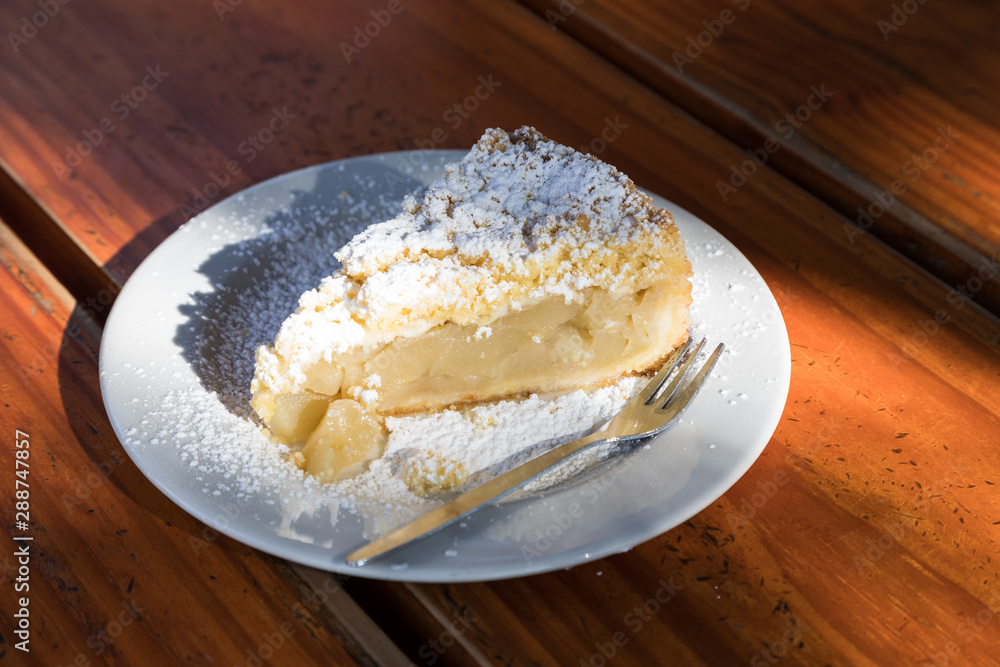 Sun illuminating a scrumptious slice of apple cake on a wooden table Sun illuminating a scrumptious slice of apple cake on a wooden table